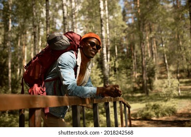 Joyful black young man spend trip in forest, seek for unknown path for camping. Explore new places, fun leisure time, wildlife. Travelling and open new horizons, wanderer, mountain concept. Copy space