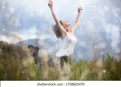 Joyful blonde girl enjoys her evening in the countryside by dancing in the rain