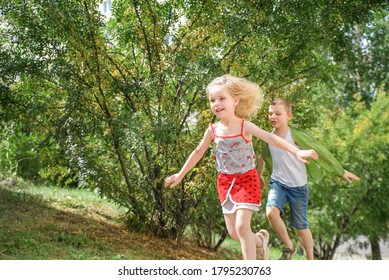joyful boy and girl running along the path on a bright sunny day, their arms spread like the wings of an airplane, freedom соncept, growing up concept
