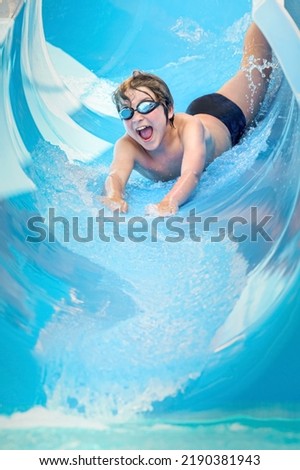 joyful boy going down the water slide in the water park, Alanya, Antalya, Turkey