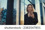 Joyful business woman talk work video call. Pretty boss lady wear black suit. 30s girl use mobile cell phone. 40s top manager walk urban city street. Fun person hold hand front camera. Job online chat