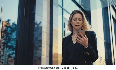 Joyful business woman talk work video call. Pretty boss lady wear black suit. 30s girl use mobile cell phone. 40s top manager walk urban city street. Fun person hold hand front camera. Job online chat - Powered by Shutterstock