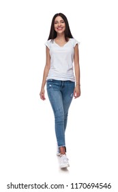 Joyful Casual Woman Wearing Jeans Walking On White Background While Smiling, Full Body Picture