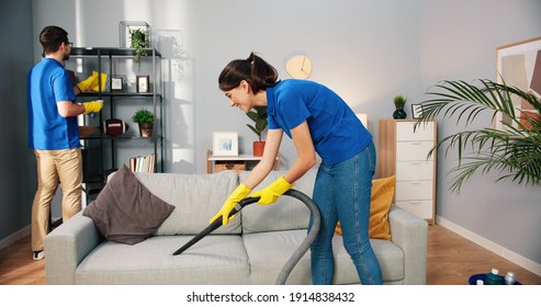 Joyful Caucasian young woman and man cleaners work cleaning client home, female vacuuming sofa in living room, guy wiping dust washing disinfecting shelves, cleaning service concept, business industry