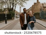 Joyful couple, Black man and woman, walk together down a charming street. Their laughter and connection highlight love and companionship in urban town. Diverse couple laughing and walking together.