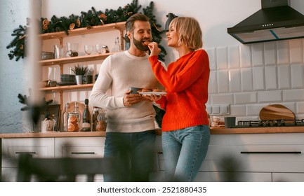 A joyful couple deeply in love shares a warm and intimate moment in a beautifully decorated kitchen during the enchanting holiday season, embodying the true essence of winter coziness and happiness - Powered by Shutterstock