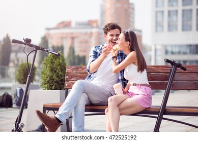 Joyful couple eating doughnuts - Powered by Shutterstock