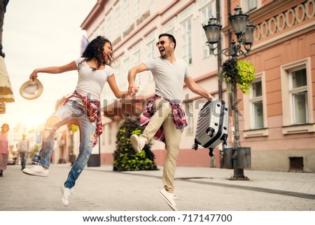Joyful couple enjoying walking at street. Find your travel partner.
