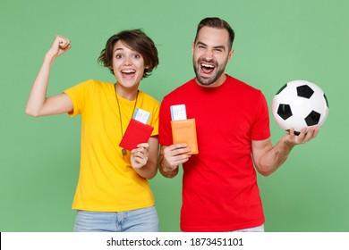 Joyful Couple Friends Sport Family Woman Man Football Fans In T-shirts Cheer Up Support Favorite Team With Soccer Ball Hold Passport Tickets Doing Winner Gesture Isolated On Green Background Studio