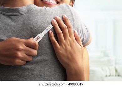 Joyful couple with positive pregnancy shown in the test device