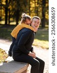 Joyful dad hugs his little smiling daughter. Single daddy and child have fun, laugh and enjoy nature outdoors at autumn park. Concept of parental care and happy carefree childhood. Happy fathers day.