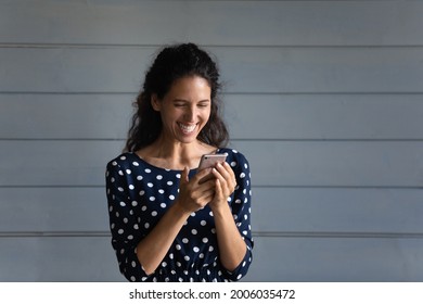 Joyful Excited Cellphone User Reading On Digital Screen And Laughing Out Loud. Happy Woman Using Virtual App, Online Service For Texting, Chatting Checking Messages, Email, Looking At Display, Smiling