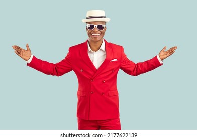 Joyful extravagant dark-skinned man in a suit spreads his arms welcoming and greeting you on pastel light gray background. Man in red suit makes hospitable gesture, invites you or is glad to see you. - Powered by Shutterstock