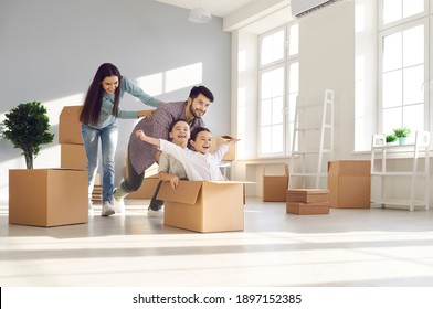 Joyful family with kids having fun in new home. Happy excited first-time buyers with children playing with boxes in the living room. Real estate, residential mortgage, moving into dream house concept - Shutterstock ID 1897152385