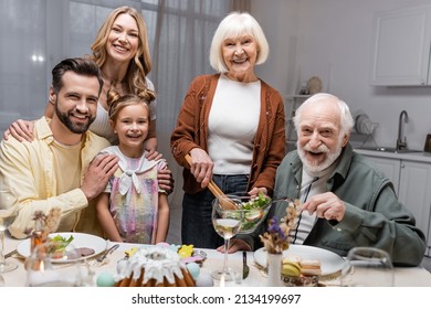 joyful family looking at camera near table served with festive easter dinner