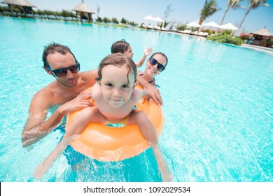 Joyful Family Playing In Swimming Pool Of Hotel, Fish Eye Lens