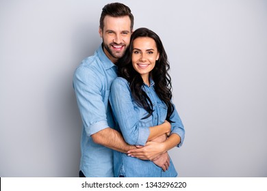 Joyful family. Portrait of isolated cute recently married people pregnant waiting for baby in warm sweet cuddles dressed in denim shirts over argent background - Shutterstock ID 1343296220