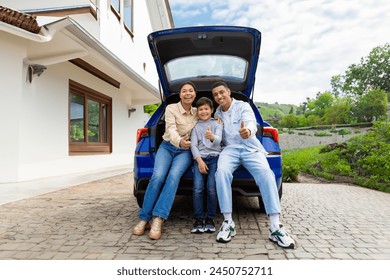 Joyful family, posing next to their luxury car outdoors outside the house, smiling at the camera. Car leasing and ownership - Powered by Shutterstock