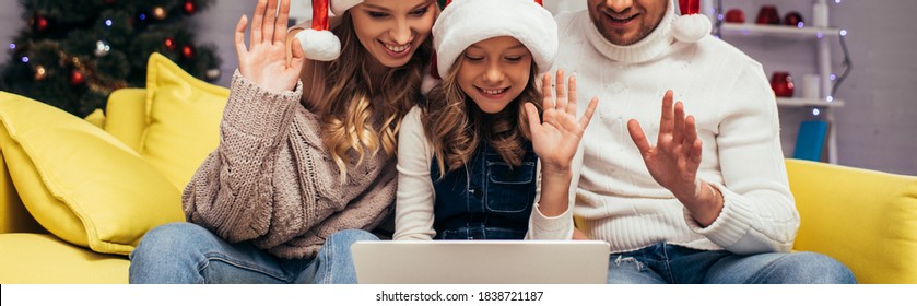 Joyful Family In Santa Hats Waving Hands While Having Video Chat On Christmas, Banner