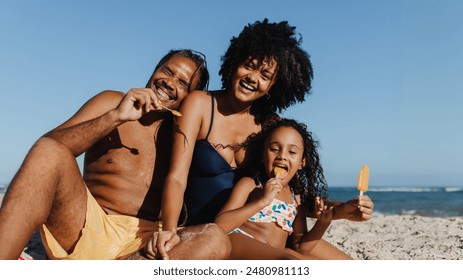 Joyful family spending a sunny day at the beach on summer vacation, enjoying ice cream together. - Powered by Shutterstock