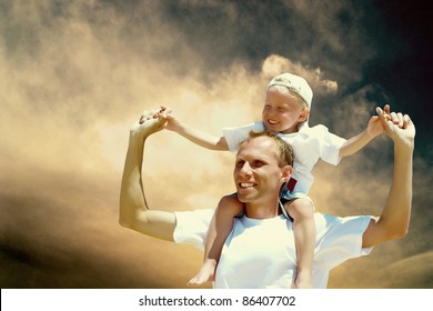 Joyful father giving piggyback ride to his son against a sky background