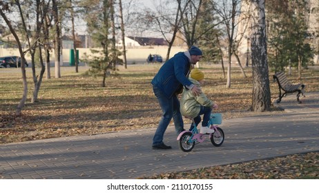 Joyful Father Teache Little Child Ride Two-wheeled Bike Happy Family, Childhood Dream Drive Bicycle Kid Dad Play Merrily City Park, Baby Spins Pedals Wheels, Parent Engaged Horse Riding With Daughter