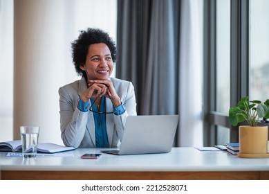 Joyful female african-american company manager in a suit, taking a breather, at the office. - Powered by Shutterstock