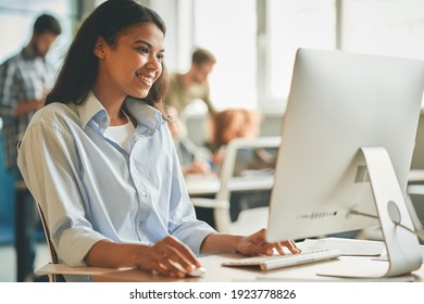 Joyful Female Office Worker Using Her Workplace Computer