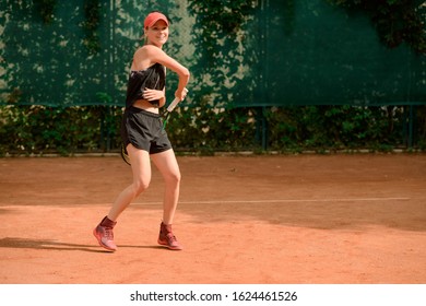 Joyful female tennis player having a good game at an outdoor court. Perfect fit body, racket skills and uplifted mood. Sport and lifestyle. - Powered by Shutterstock