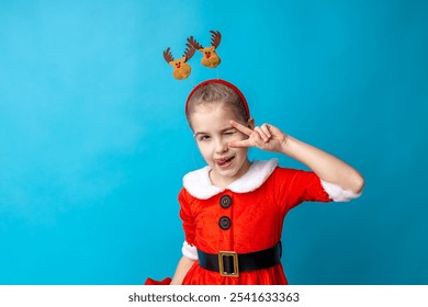 A joyful girl dressed in a classic red Christmas outfit poses with a playful peace sign while wearing whimsical reindeer antlers, epitomizing holiday spirit. - Powered by Shutterstock