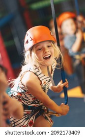 Joyful Girl At Indoor Climbing Wall. Kid In Helmet Having Fun At Bouldering Wall. Child Learning At Climbing Class. Family Sport, Healthy Lifestyle, Happy Family. 