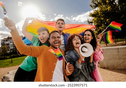 joyful group of diverse friends celebrating LGBTQ, waving rainbow flags and holding a megaphone. - Powered by Shutterstock