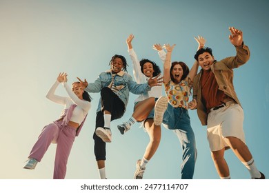 Joyful group of friends jumping together outdoors, capturing happy and fun moments in the sunshine. The sky in the background enhances their exhilaration. - Powered by Shutterstock