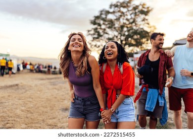 A joyful group of friends are at a summer day festival having a fun time together enjoying a nice day. - Powered by Shutterstock