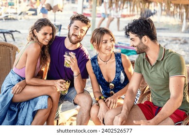 Joyful group of young adults sharing cocktails and laughter on a sunny beach bar setting, embodying summer vibes and friendship. - Powered by Shutterstock