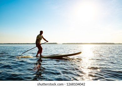 Joyful Guy Paddling On Sup Board Stock Photo (Edit Now) 1268104030