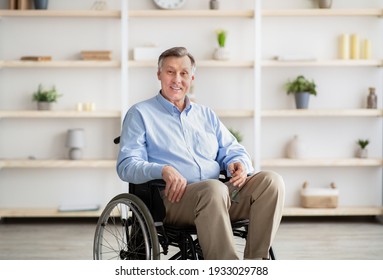 Joyful handicapped senior man in wheelchair smiling and looking at camera at retirement home. Portrait of positive disabled elderly male feeling happy and optimistic - Powered by Shutterstock