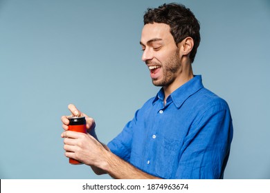 Joyful Handsome Guy Smiling While Opening Soda Can Isolated Over Blue Background