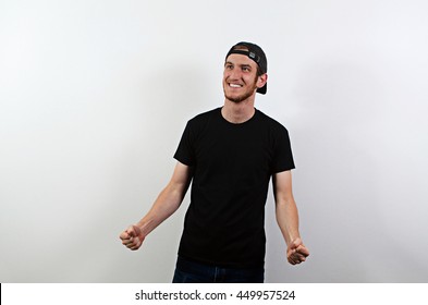 Joyful Happy Smiling Young Adult Male In Dark T-Shirt And Baseball Hat Worn Backwards