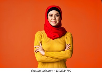     joyful hijab woman in a red veil on an orange background                            - Powered by Shutterstock