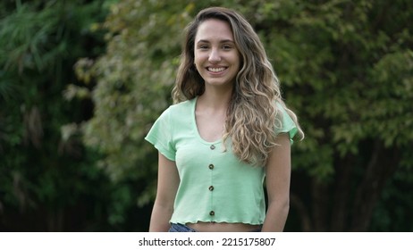 Joyful Hispanic Latina Girl Standing Outside Smiling. Young Woman Latina Portrait. Millennial 20s Female Person In Tracking Shot.