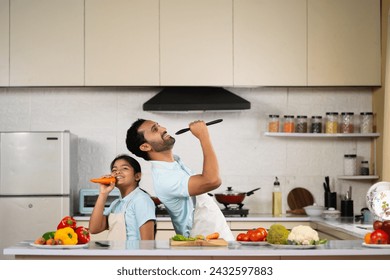 Joyful Indian father with kid dancing together at kitchen while cooking - concept of weekend holidays, family bonding and happy parenting - Powered by Shutterstock