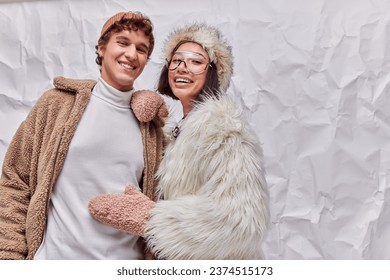 joyful interracial couple in fashionable warm outwear on white textured backdrop, winter fashion - Powered by Shutterstock