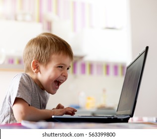 Joyful kid playing games on laptop.