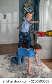 Joyful Kid Working Out Assisted By His Younger Sibling