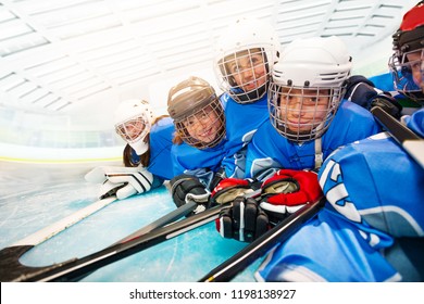 Joyful Kids In Hockey Uniform Laying On Ice Rink