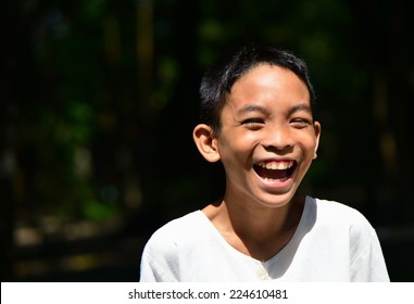 Joyful  Laughing Or Smiling Asian Kid Boy In White Shirt 