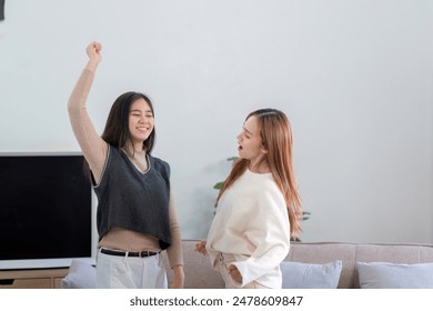 Joyful Lesbian Couple Dancing at Home in Modern Living Room, Celebrating Love and Happiness Together - Powered by Shutterstock