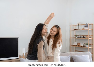 Joyful Lesbian Couple Dancing Together in Modern Cozy Living Room with Minimalist Decor - Powered by Shutterstock