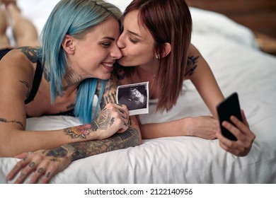 Joyful Lesbian Couple Sharing Hapiness Of A Pregnancy Together